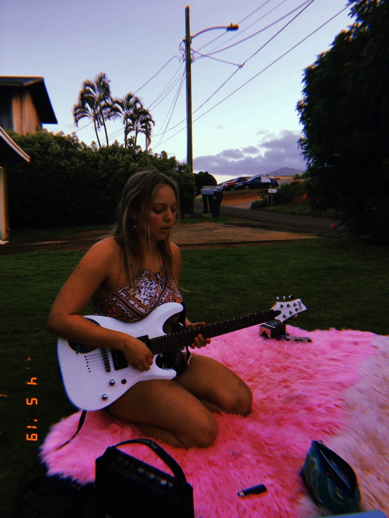 Larimar playing guitar on the beach